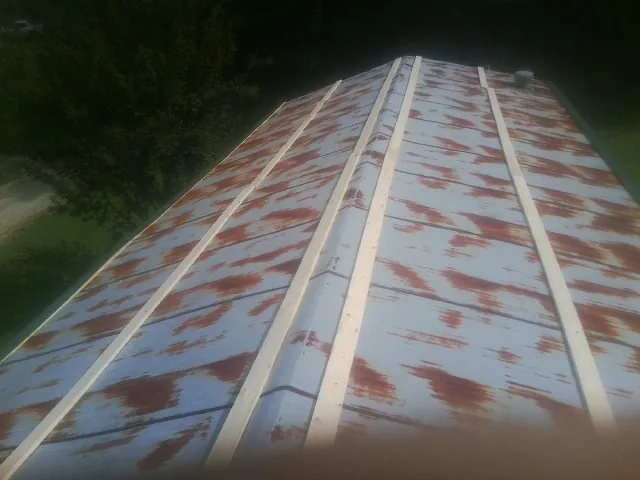 Rusted metal roof panels with new wood purlins before replacement — Storm Damage Roof Repair in Norcross by Roofing Brothers